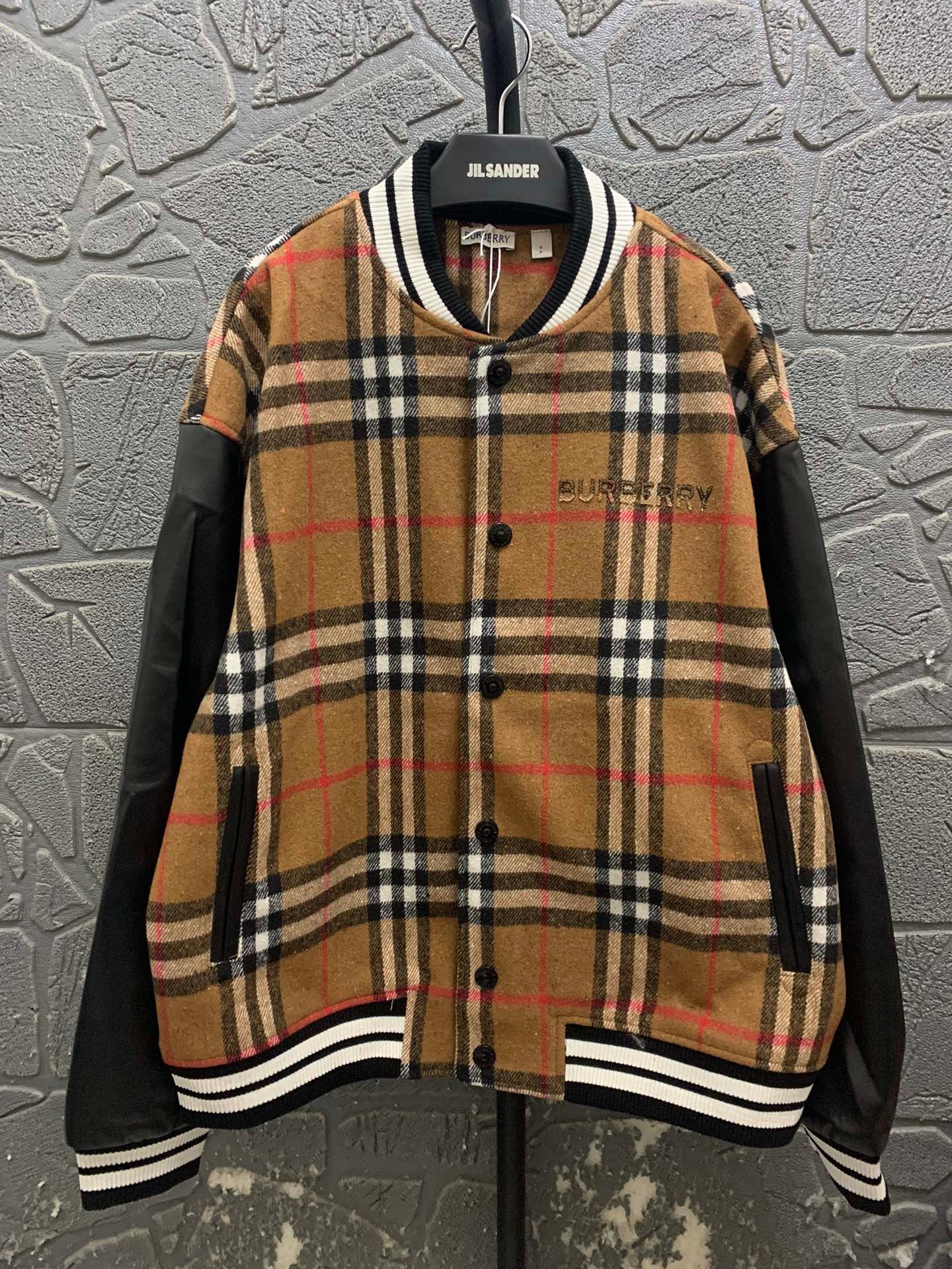 Burberry patchwork knit sweater paired with a baseball jacket featuring spurs-embroidered letter pattern 111210